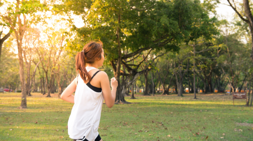 Jeune femme en train de courir dans un parc