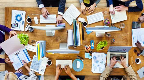 Image vue d'avion d'une table avec des personnes en train de travailler sur des équipements informatiques