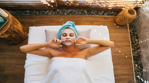 Jeune femme allongée, avec un masque de beauté sur le visage