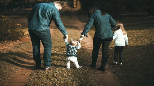 Famille de 4 personnes de dos, dans la nature