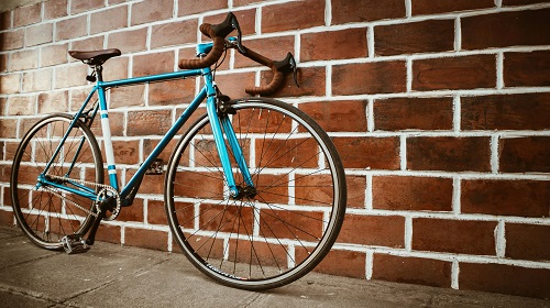 Vélo posé contre un mur de brique