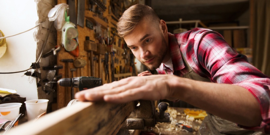 jeune homme travaillant le bois