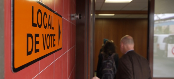 Deux membres de la CEC entrent dans un local de vote. 