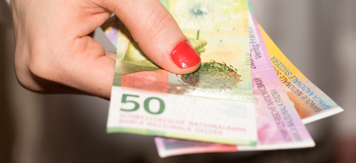 Main tenant des billets de francs Suisse