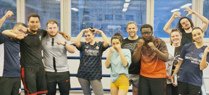 Des jeunes prennent la pose, en position de boxeuses et boxeurs ou en faisant des cœurs avec les doigts, dans une salle de sport Des jeunes prennent la pose, en position de boxeuses et boxeurs ou en faisant des cœurs avec les doigts, dans une salle de sport
