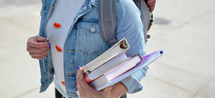 Femme portant une veste en jean bleue tenant des livres. Photo de Element5 Digitalsur Unsplash