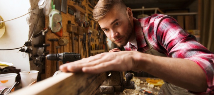 jeune homme travaillant le bois