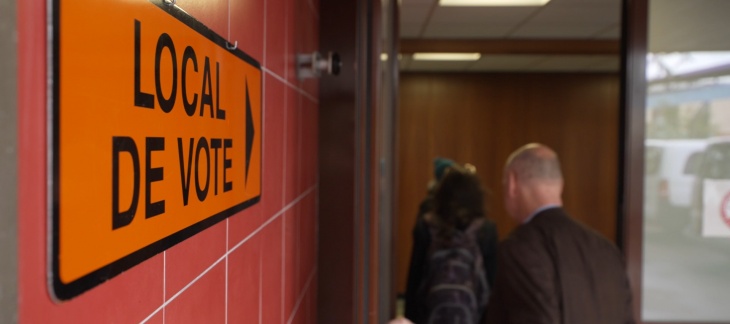 Deux membres de la CEC entrent dans un local de vote.