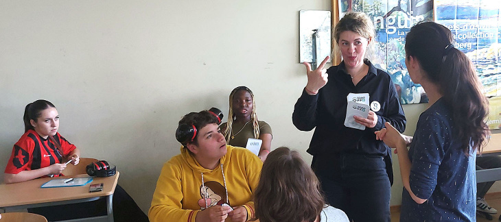 L'animatrice de l'atelier dialogue avec les élèves qui comprennent ses signes grâce à la traduction orale de l'interprète