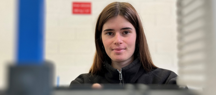 Skye Parrott, apprentie automaticienne, devant une machine