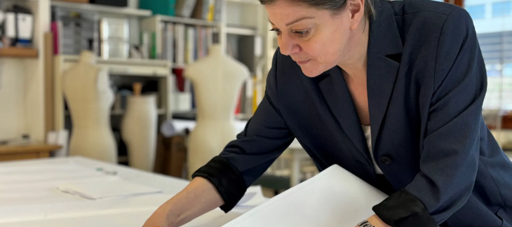 Laurence Imstepf découpe un patron dans son atelier à Versoix.