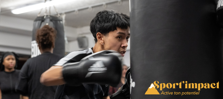 Un jeune tape dans un sac avec des gants de boxe 