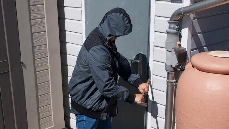 voleur qui essaie de forcer une porte