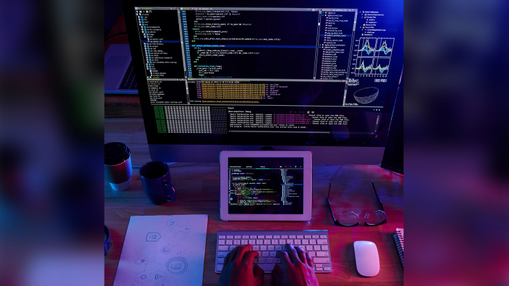 Une personne avec plusieurs écrans d'ordinateurs face à elle