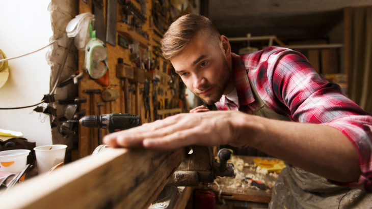 jeune homme travaillant le bois