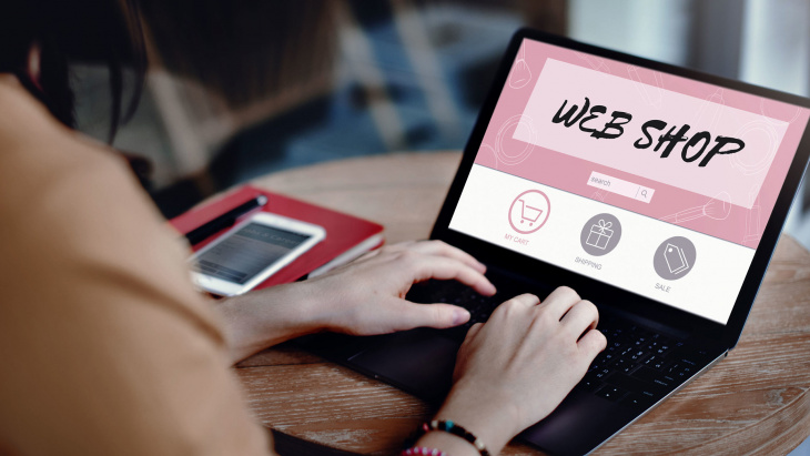 une personne avec l'ordi ouvert qui s'apprête à faire des achats en ligne