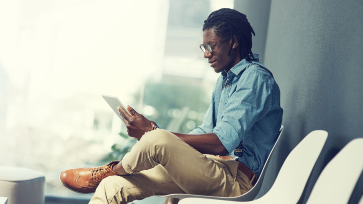 Homme assis consultant une tablette