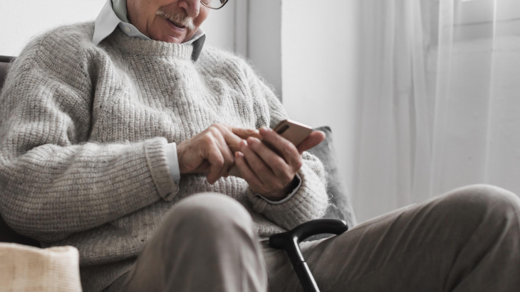 Un senior avec son portable dans les mains