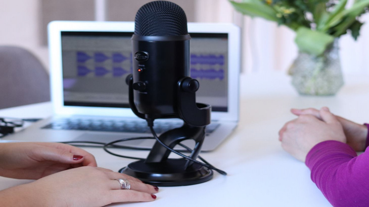 mains féminines devant un micro