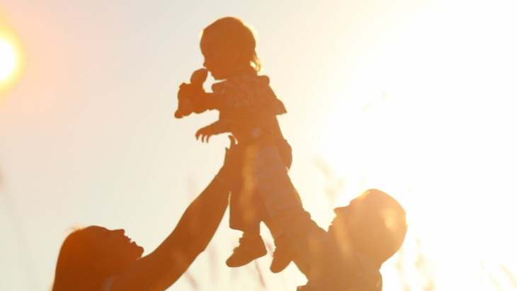 Parents qui portent un enfant vers le ciel