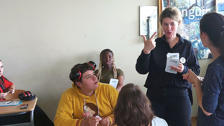 L'animatrice de l'atelier dialogue avec les élèves qui comprennent ses signes grâce à la traduction orale de l'interprète