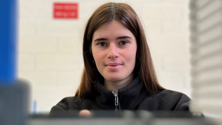 Skye Parrott, apprentie automaticienne, devant une machine