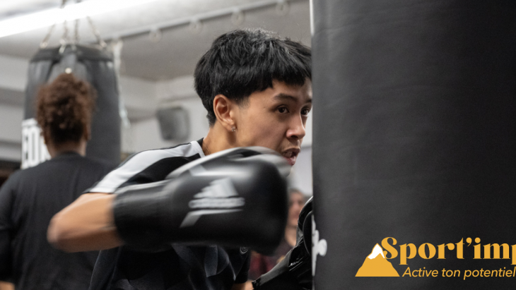 Un jeune tape dans un sac avec des gants de boxe 